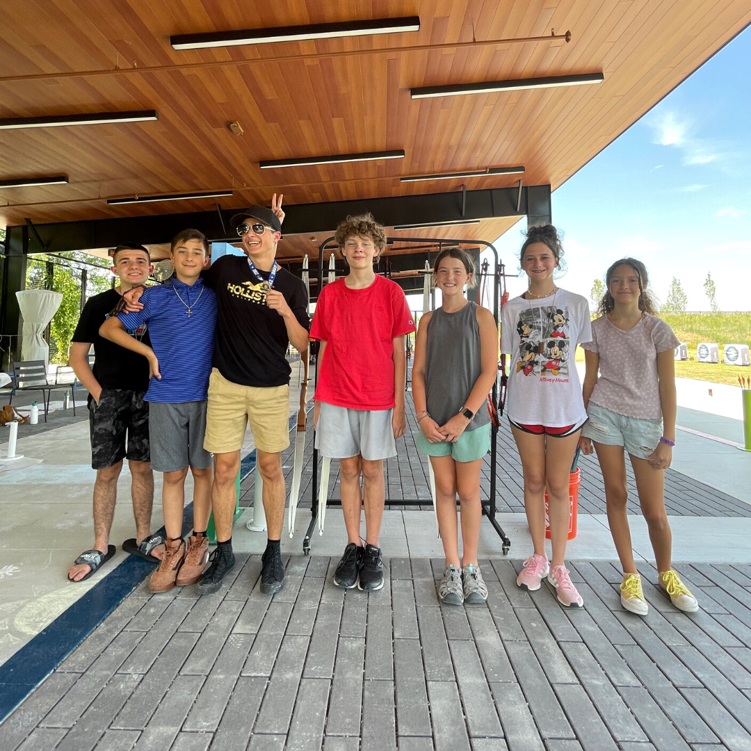 Kids smiling and standing for a photo at The Quiver Archery Range after a fun week of Explore Archery Camp