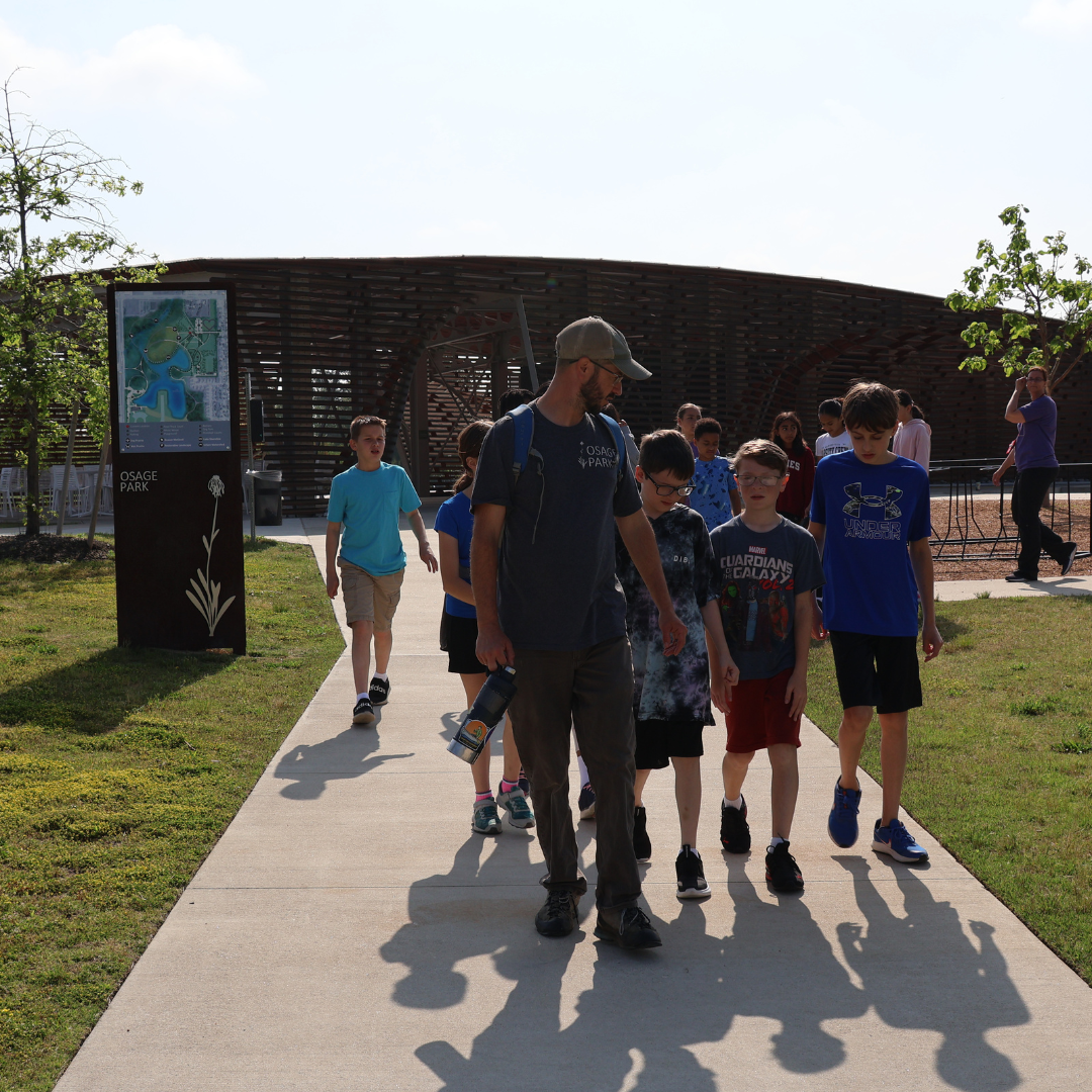 Group of kids leaving the Osage Park pavilion heading toward the wetlands for an adventure