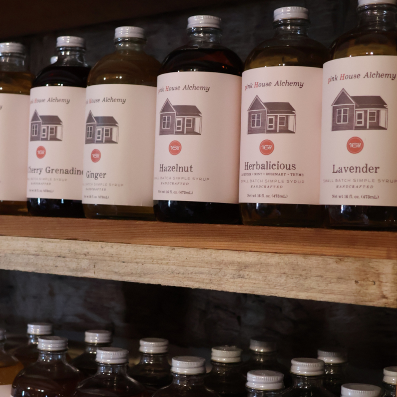 Pink House Alchemy Syrups on wooden shelf in glass bottles at Peel Museum Store located in NWA Bentonville, Arkansas 