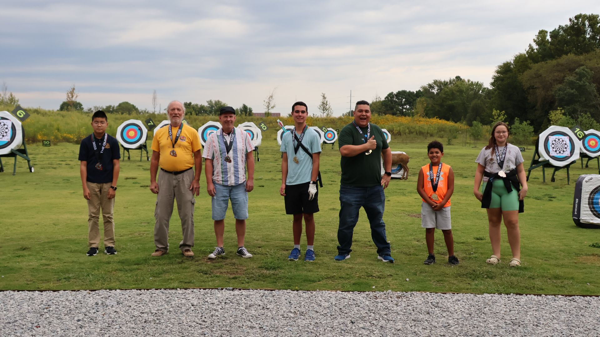 Group of Members at the Quiver Archery Range outdoors with bright targets behind them in bentonville, Ar