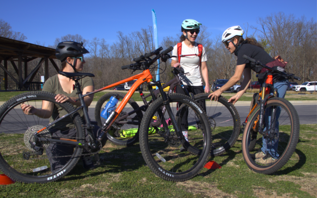 Women checking their bikes while starting the Level 1 MTB Class at Coler